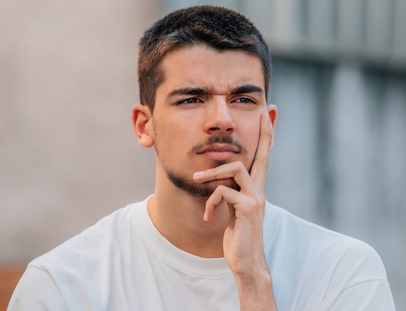  Ein junger Mann, der mit einer Frage belästigt wird