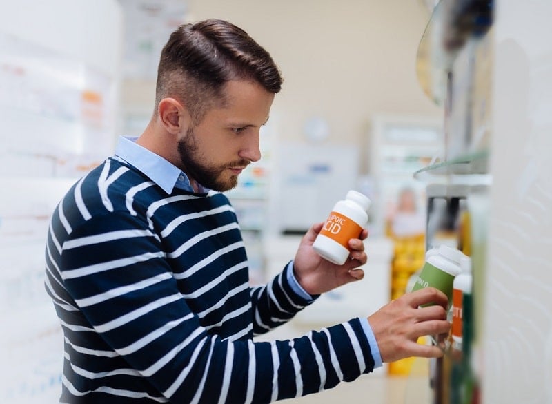 Ein Mann sucht in einer Apotheke nach einem natürlichen Potenzmittel